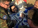 Hazza Al Mansoori back to Earth, covered in UAE flag